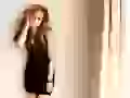 Avril Lavigne in a black dress at a wall