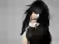 Dark-haired Christina Aguilera in black on a grey background